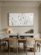 Close-up of large 3D textured painting by Lucien Hoffmann featuring tiny colorful skiers on a heavy white impasto snow mountain canvas.