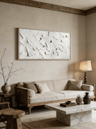 Close-up of large 3D textured painting by Lucien Hoffmann featuring tiny colorful skiers on a heavy white impasto snow mountain canvas.