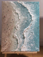 Aerial view of turquoise ocean waves with 3D textured white foam and tiny people on the beach, hand-painted by Leo Liang.