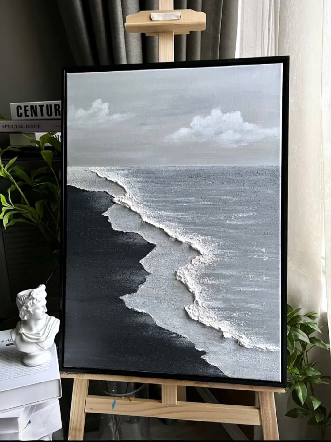 Close-up of a hand-painted 3D textured black sand beach painting with heavy white sculpted seafoam and black waves in a black frame.