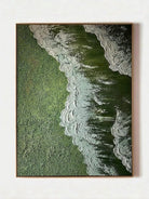High-relief 3D textured painting showing white sculpted seafoam splashing over a deep forest green background in a gold frame.