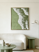 High-relief 3D textured painting showing white sculpted seafoam splashing over a deep forest green background in a gold frame.