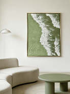 High-relief 3D textured painting showing white sculpted seafoam splashing over a deep forest green background in a gold frame.