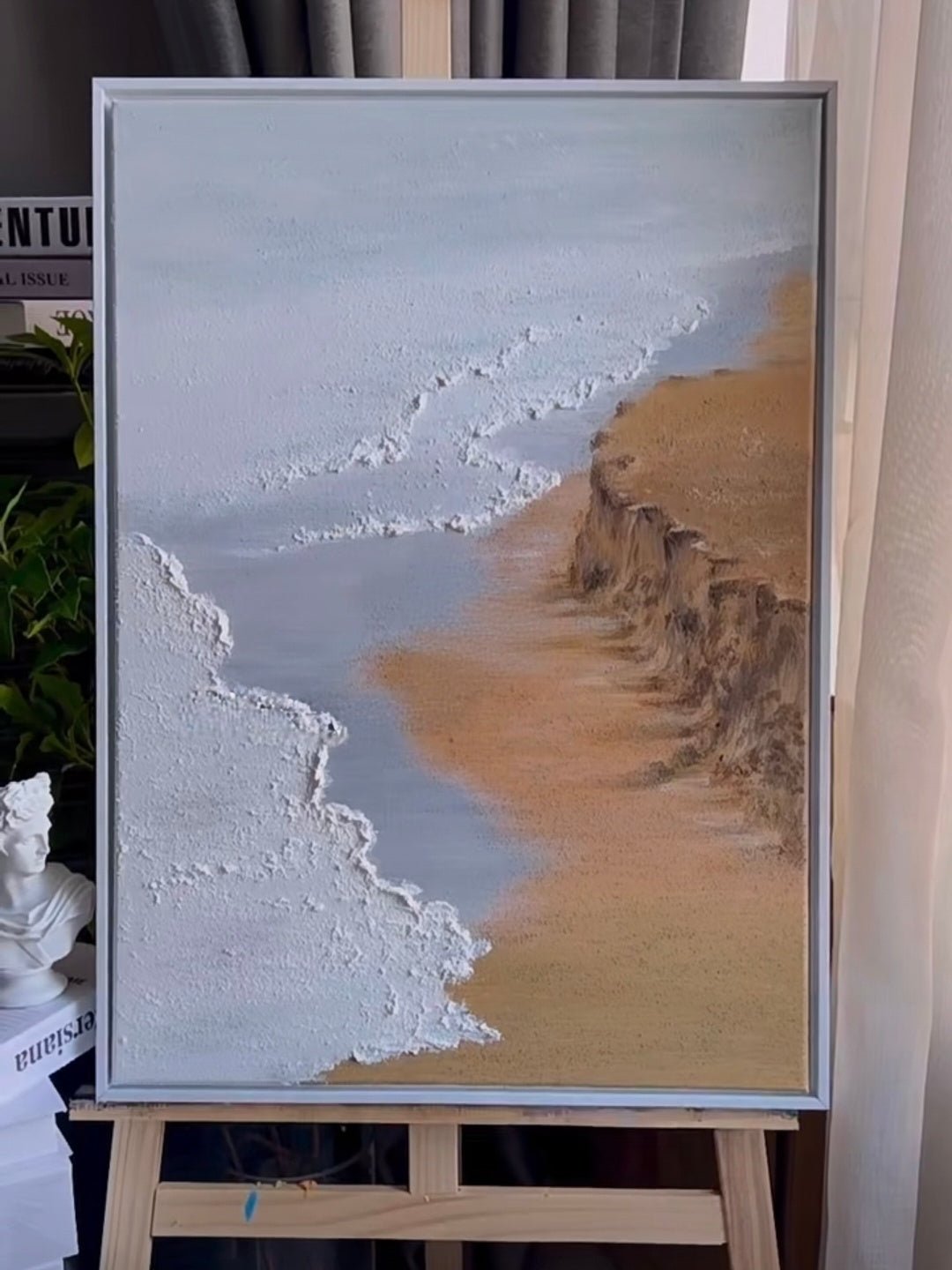 Large vertical hand-painted ocean seascape painting with heavy impasto white foam waves and golden cliffs by Leo Liang in a modern living room.