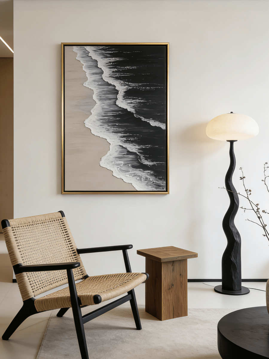 Large vertical hand-painted black ocean painting with heavy 3D white foam texture and beige sand by Leo Liang in a modern minimalist interior.