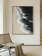Large vertical hand-painted black ocean painting with heavy 3D white foam texture and beige sand by Leo Liang in a modern minimalist interior.