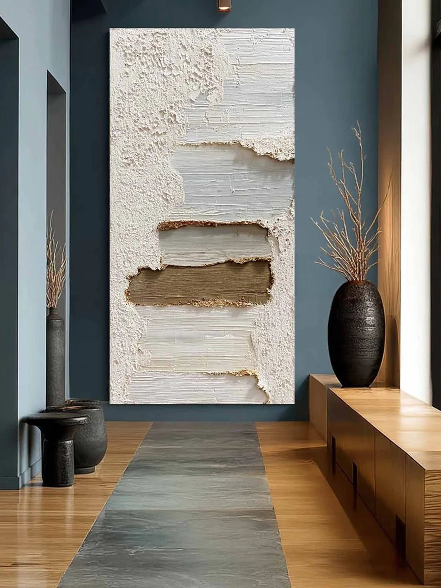 A tall vertical 3D textured abstract painting by Leo Liang featuring heavy plaster-like layers of white, taupe, and gray in a modern living room with a fireplace.