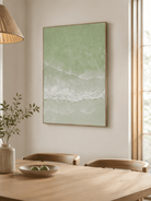 Hand-painted sage green coastal wall art displayed in a dining room with natural wood furniture