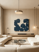 Minimalist geometric painting hanging above a mid-century modern sofa in a living room.