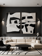 A pair of modern minimalist oil paintings with bold geometric shapes hanging as a diptych above a contemporary living room sofa.