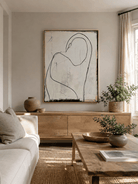 Minimalist female figure painting above a neutral sofa in a wabi-sabi living room