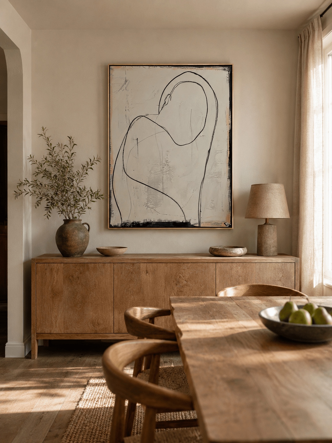 Abstract female figure wall art displayed in a neutral open-plan dining room