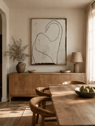 Abstract female figure wall art displayed in a neutral open-plan dining room