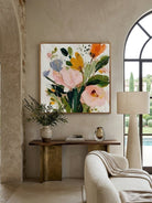 Large square 3D textured floral painting showing heavy impasto yellow and peach flowers on a white background in a modern bright living room.