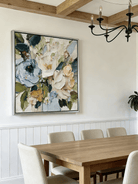 Large square 3D textured floral painting showing heavy impasto green and white flowers in a modern bright living room.