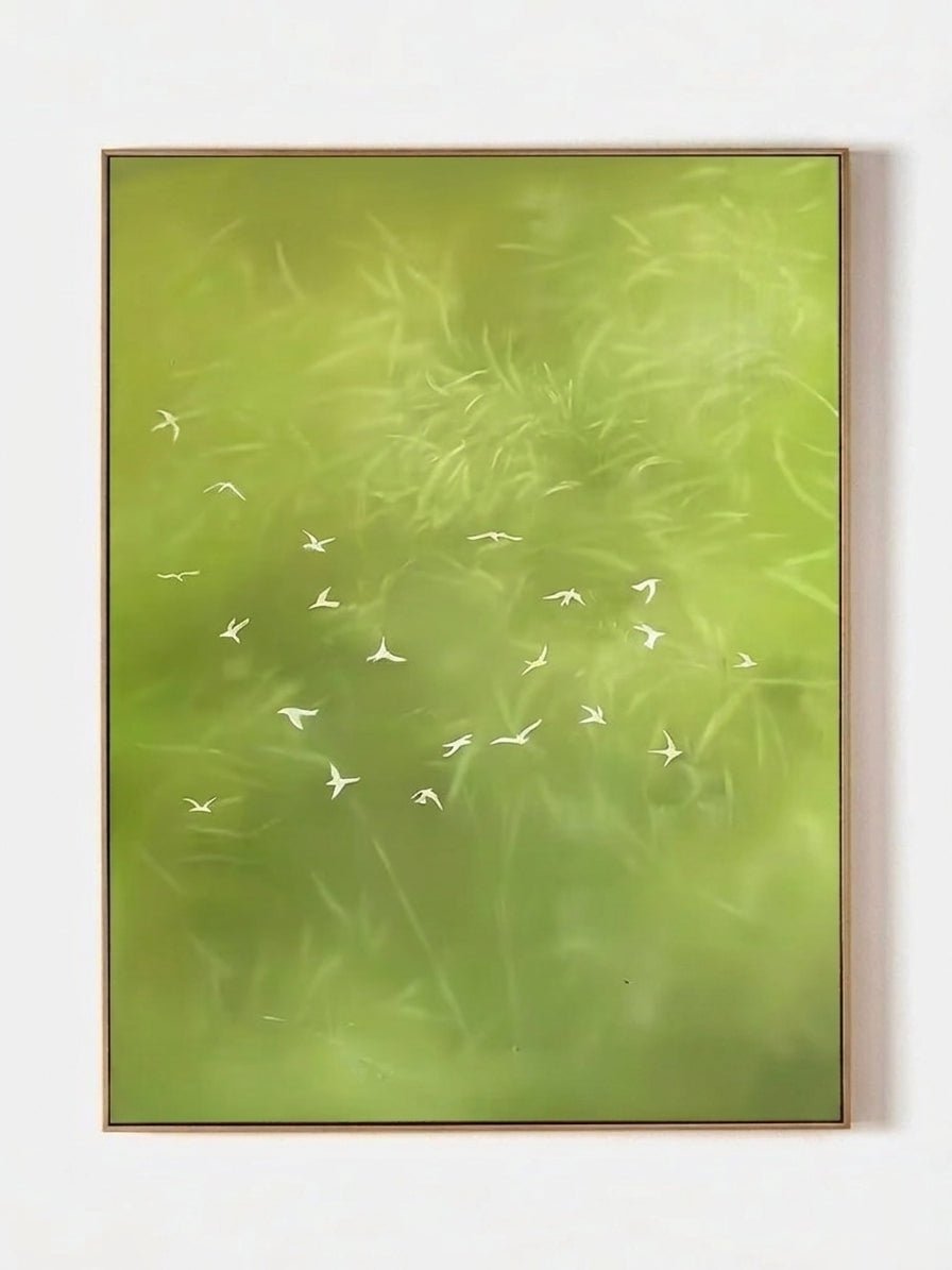 Large vertical hand-painted abstract forest painting in sage green with white flying birds by Luna Xiao in a modern neutral bedroom.