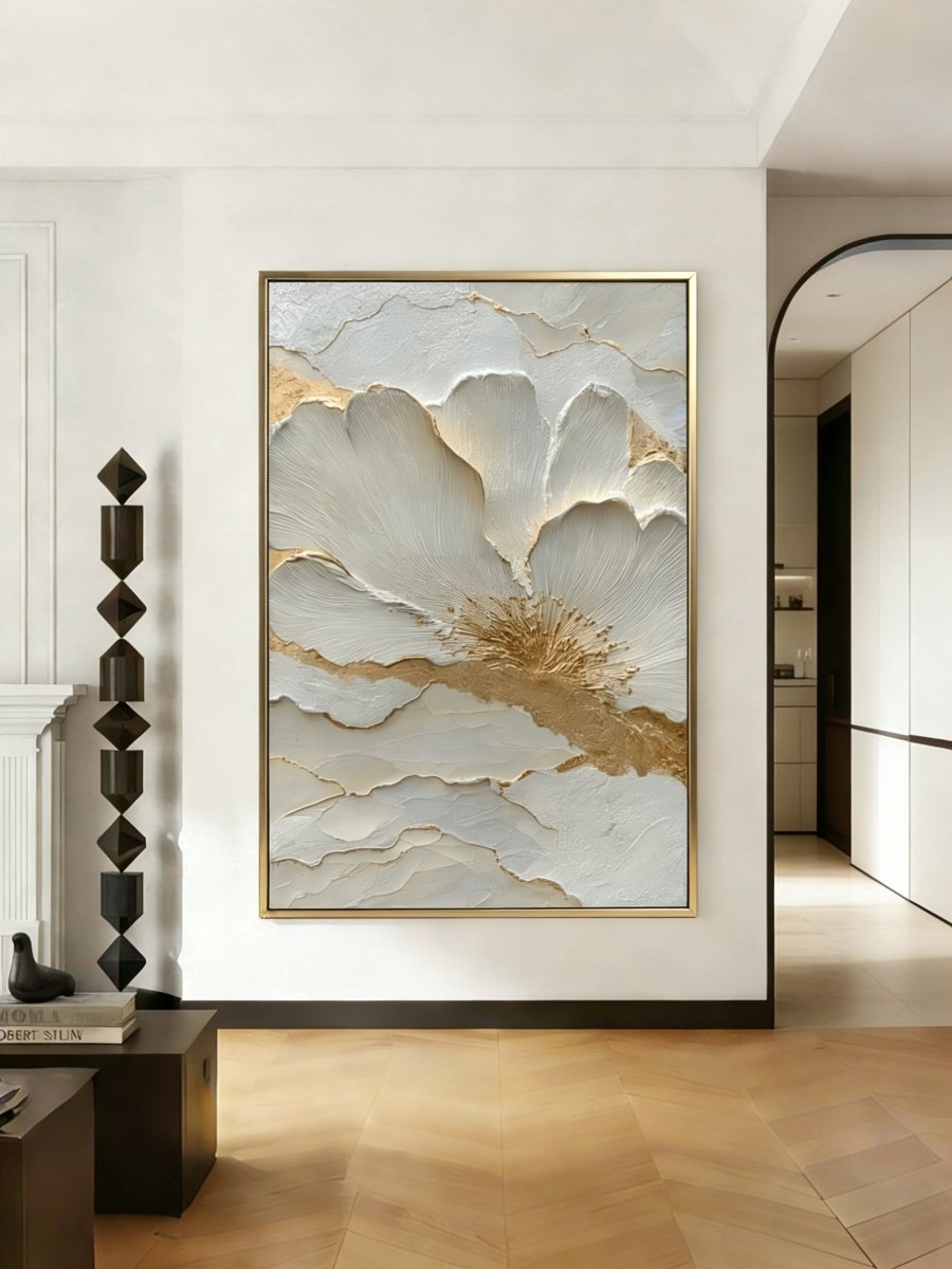 Close-up view of heavy 3D sculptural white flower petals with gold foil edges on canvas, hand-painted by Luna Xiao in a minimalist living room setting.