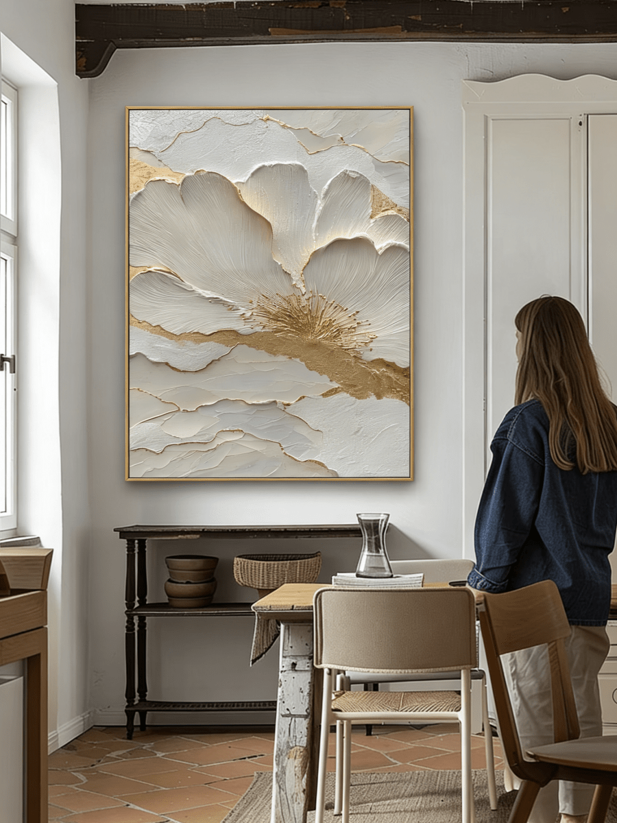 Close-up view of heavy 3D sculptural white flower petals with gold foil edges on canvas, hand-painted by Luna Xiao in a minimalist living room setting.