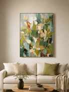 Large green botanical wall art displayed beside a beige sofa in a contemporary organic modern living room