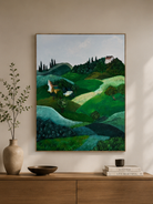 Rolling hills and countryside villa painting displayed above a wood console in a warm modern entryway