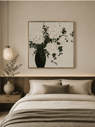 Textured white floral wall art displayed above the bed in a calm modern bedroom