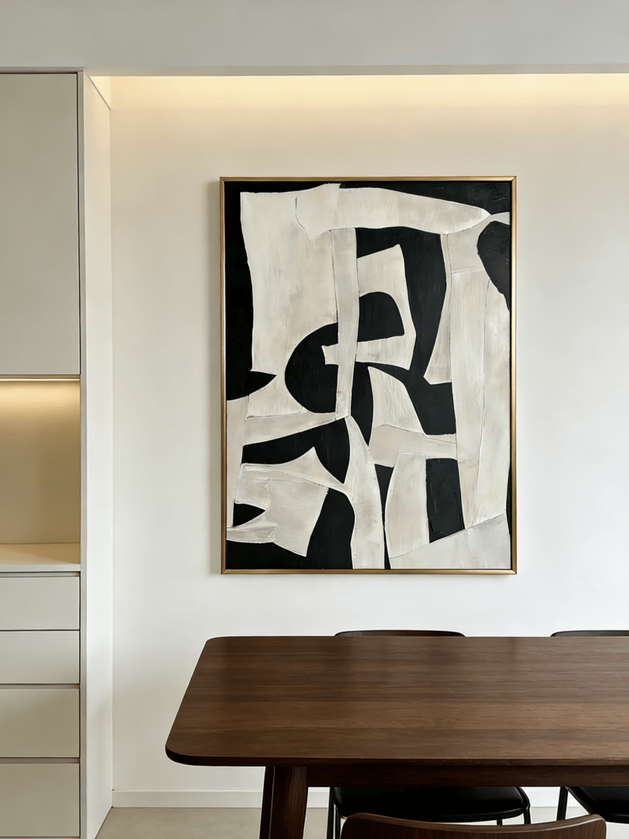Large vertical hand-painted abstract painting with bold black and white geometric shapes and heavy impasto texture by Seraphina Rose in a modern luxury living room.