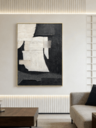 Large vertical hand-painted abstract painting with black and white textured blocks and fabric-like impasto by Seraphina Rose in a modern luxury living room.