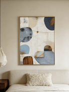 Hand-painted modern organic abstract painting featuring blue and brown geometric shapes with thick texture in a gold floater frame.