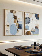 Large 2-piece hand-painted abstract diptych with organic blue and terracotta shapes and heavy texture by Seraphina Rose in a modern coastal living room.