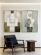 A pair of large vertical abstract paintings with geometric totem-like shapes in sage green, olive, and beige with visible heavy texture.
